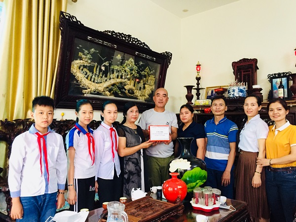 Đại diện BGH, BCHCĐ, Hội CMHS và các em học sinh Trường Tiểu học Thanh Cao trao quà ủng hộ tới gia đình em Lê Bá Minh Kiên